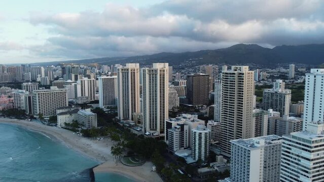 4K cinematic clockwise drone shot of Waikiki Beach and the towering hotels that line the area in Oahu. This vibrant Hawaiian cityscape was filmed just after sunrise with a DJI Mini 2 drone.