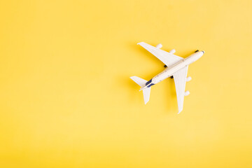 Travel flat lay composition airplane on yellow background with copy space