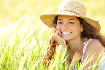 Happy woman with white smile in a field looking at camera