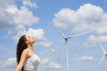 Woman breathing fresh air in a wind farm
