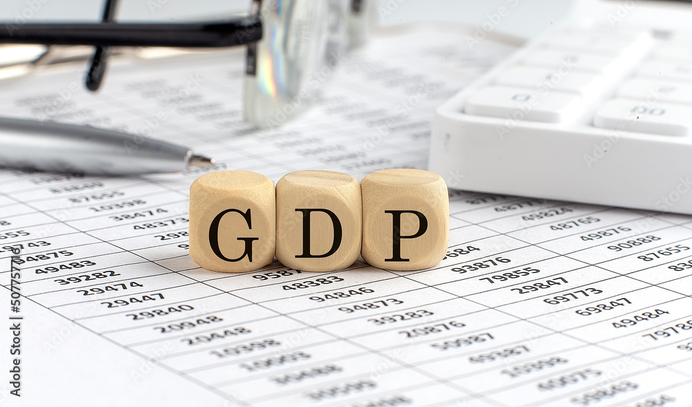 Wall mural wooden cubes with the word gdp on a financial background with chart, calculator, pen and glasses, bu