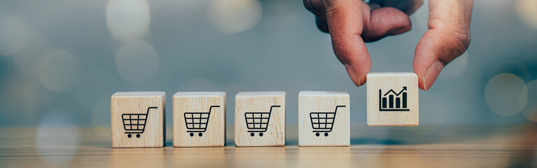 Hands flips cube with icon shopping cart symbol, sale volume increase make business grow. Banner cover design.