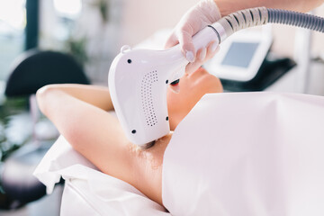 Woman on laser hair removal treatment on underarm