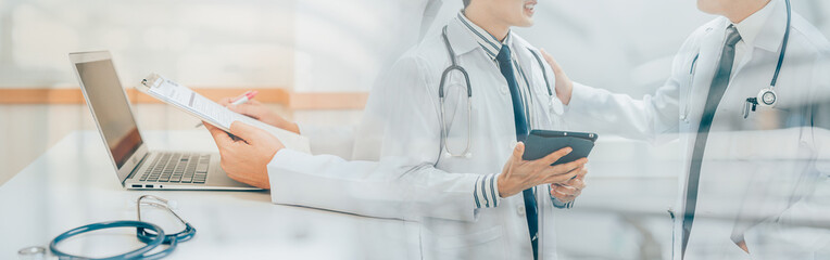 Male Doctor expert wearing white coat using laptop and reading clipboard report at work in hospital. Banner cover design.