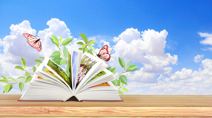 Book of nature. Horizontal banner with book open, green leaves and two butterflies on wood table