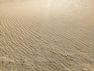 Embossed texture of sand on the beach, grit close up.