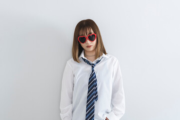 ハートのサングラスをかけてピースサインをする女子高生