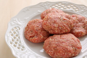 Homemade hamburger patty on white plate for prepared cooking ingredient 