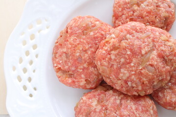 Homemade hamburger patty on white plate for prepared cooking ingredient 