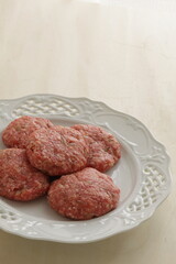 Homemade hamburger patty on white plate for prepared cooking ingredient 