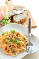 Italian food, cream sauce and spring onion fettuccine pasta on white plate 