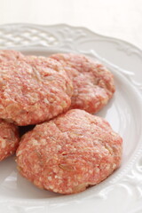 Homemade hamburger patty on white plate for prepared cooking ingredient 