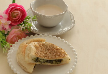 Asian food dumpling, vegetable in sesame bun and tea