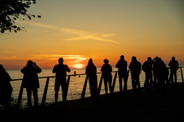 Ludzie oglądający zachód słońca nad polskim morzem