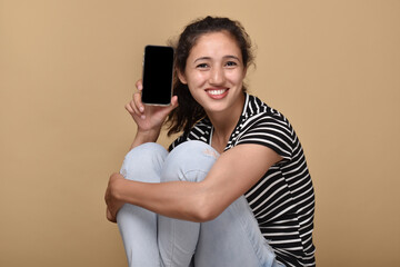 Naklejka premium Young woman showing blank screen of smartphone 