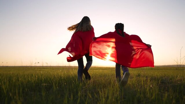 happy family.Super kid play in park.Strong successful girl in red raincoats at sunset in summer.Happy family joy in park.Child play superhero.Child dream in nature in field.Superhero run on grass