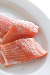 Prepared Salmon fish fillet on white plate for cooking ingredient image