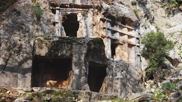 View of antique rock burial chambers in ancient Lycian city of Pinara in Turkey. Examples of ancient rock cut architecture