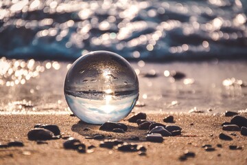 Abstract holiday seaside idea. Sea landscape held in a glass ball with a blurred background.