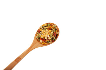Green and yellow crushed dry peas with spices in a wooden spoon on white background. Ingredients for Indian pea soup with curry