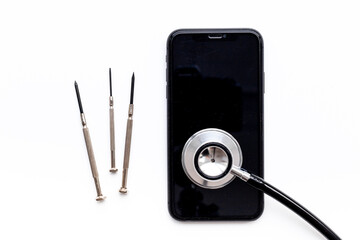 Fototapeta na wymiar Electronics repair servise concept - mobile phone with stethoscope