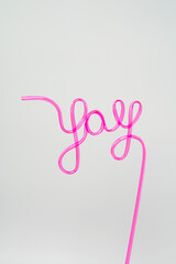 Fototapeta premium Yay script drinking straw in neon pink on white background
