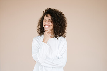 Studio portrait smiling dark skinned female with African haircut isolated over brown background