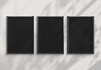 Three billboards hanging on a sunlit wall mockup. Template of frames bathed in sunlight 3D rendering