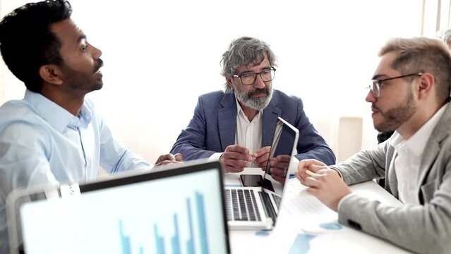 three multiracial coworkers of different ages, in the creative office discussing - business concept -