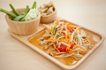 Som Tam, Thai Green Papaya Salad. It's a combination of thin strips of unripe papaya, green beans, tomatoes, carrots, chilli, lime juice, garlic, palm sugar, fish sauce and roasted peanuts.