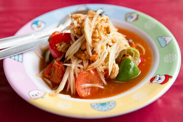 Som Tam, Thai Green Papaya Salad. It's a combination of thin strips of unripe papaya, green beans, tomatoes, carrots, chilli, lime juice, garlic, palm sugar, fish sauce and roasted peanuts.