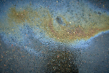 Fototapeta na wymiar Oil stain on Asphalt, color Gasoline fuel spots on Asphalt Road as Texture or Background.Close-up Oil stain on Asphalt