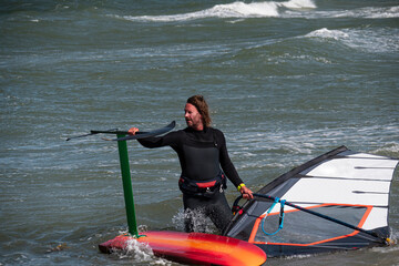 Wind foil surfer goes into the sea with his hydrofoil board