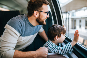 Father and son travel together by fast train and taking selfie photo.