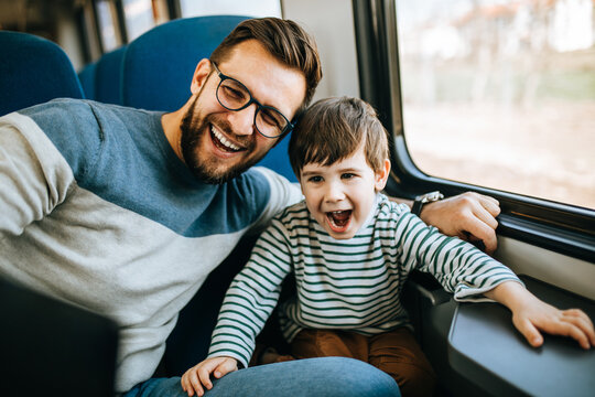 Father and son travel together by fast train and taking selfie photo.