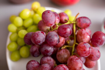 Fresh red and green grape on plate, close-up. Healthy lifestyle concept. - obrazy, fototapety, plakaty