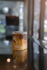 Ice coffee on a table with cream being poured into it showing the texture and refreshing look of the drink