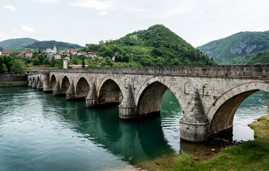 The Ottoman Mehmed Pasa Sokolovic Bridge in Visegrad, Bosnian mountains, reflected in the river Drina, Bosnia and Herzegovina.