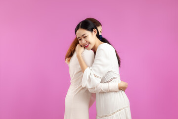 portrait of Two Young asian women hug together, concept of lgbtq Lesbian couple, pink color background.