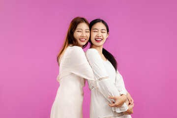 portrait of a lgbt couple, asian women in white dress over isolated pink color background