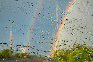 Raindrops and rainbow on the car wind glass.