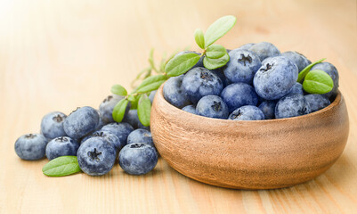 wooden plate with fresh blueberries on the table