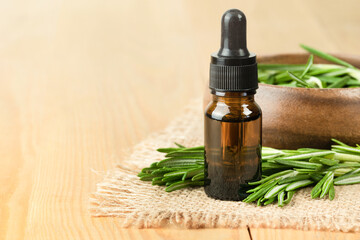 rosemary oil in a bottle and a plate with fresh rosemary