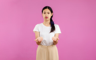 Photo of pretty asian woman in white dress posing on the pink screen background.
