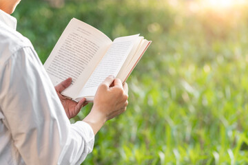 close up of person reading a book outdoors