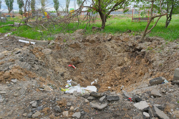 A shelling crater in a garden in a Ukrainian city.