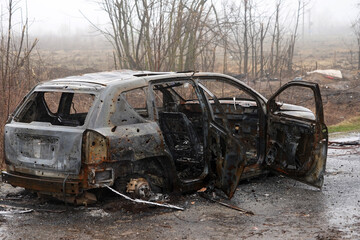 Burnt car during the war in Ukraine. Destroyed buildings, roads. Technique of civilian Ukraine.