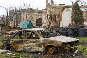 Burnt car during the war in Ukraine. Destroyed buildings, roads. Technique of civilian Ukraine.