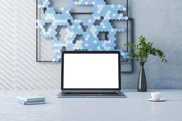 Close up of creative designer desktop with empty white laptop screen, green plant in vase and decorative mosaic, coffee cup. Mock up and 3D Rendering concept.