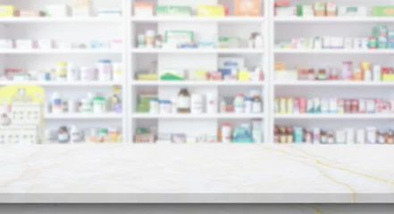 Zelfklevend Fotobehang Empty white marble counter top with blur pharmacy drugstore shelves background © Piman Khrutmuang